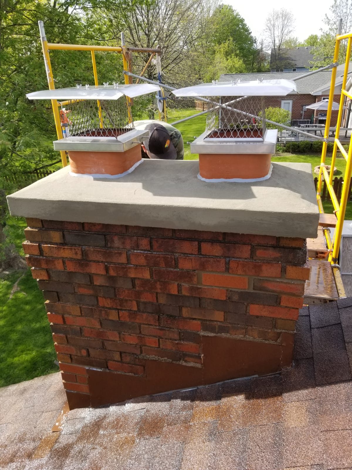 Brick chimney crown repair with stainless caps by masonry contractor Indianapolis, IN